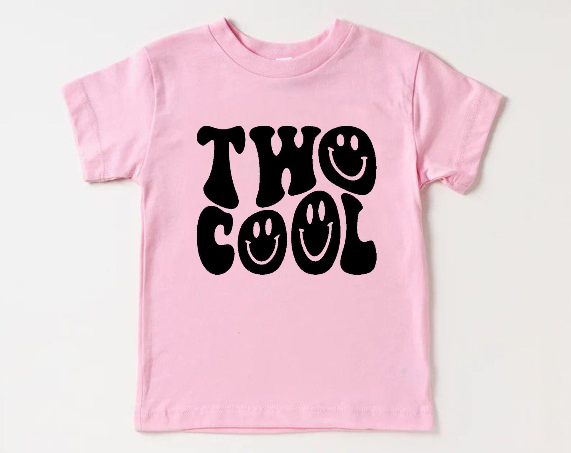 Pink t-shirt with 'Two Cool' text on a white background