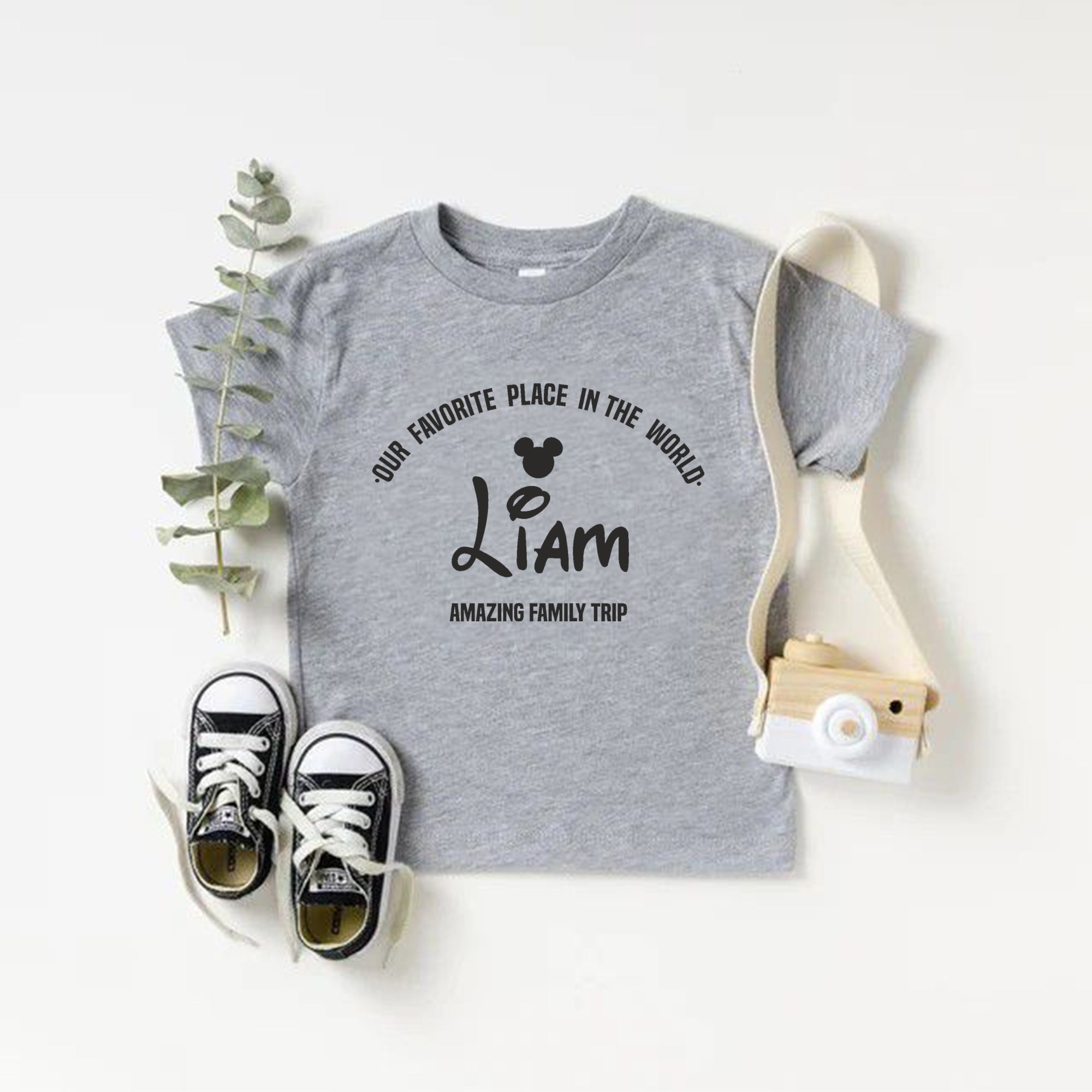 Gray t-shirt with text and black sneakers on a white background