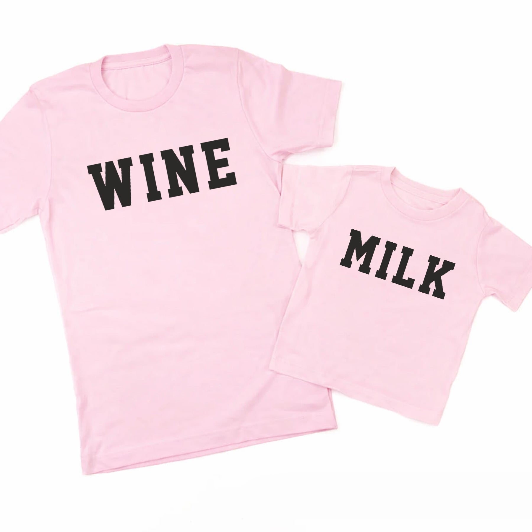 Two pink t-shirts, one with 'WINE' and the other with 'MILK', on a white background.